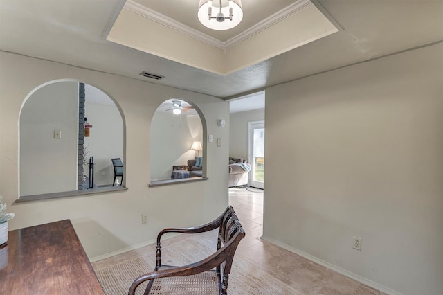 hall with a raised ceiling, light tile patterned floors, and crown molding