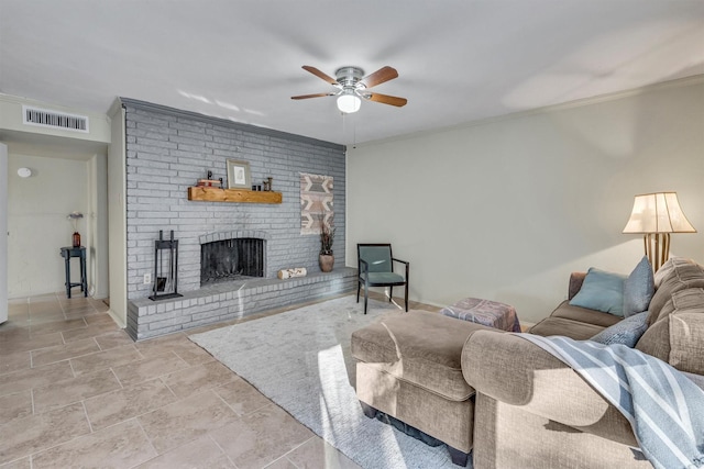 living room featuring a brick fireplace, crown molding, and ceiling fan