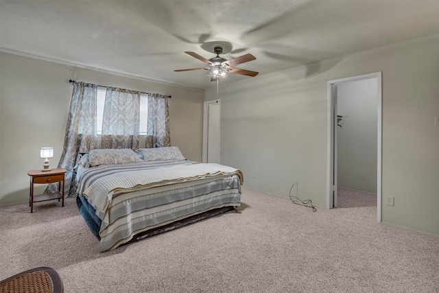 bedroom with ceiling fan, a spacious closet, and carpet flooring