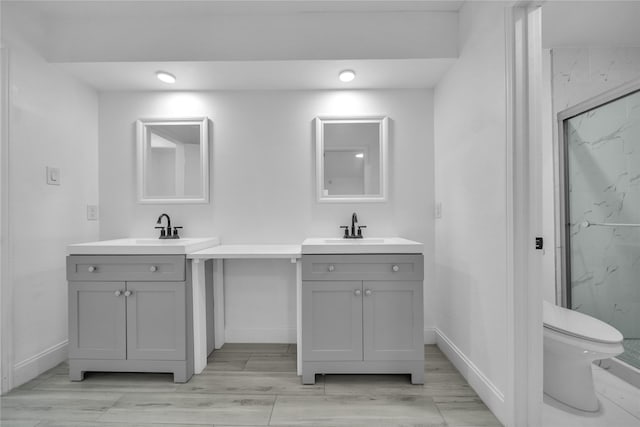 bathroom featuring vanity, walk in shower, and toilet