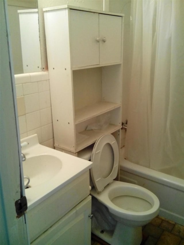 full bathroom featuring tile walls, shower / bathtub combination with curtain, vanity, and toilet