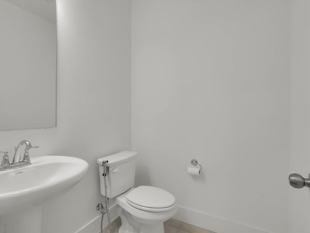 bathroom featuring toilet, tile patterned flooring, and sink