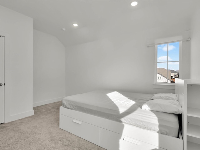 bedroom with lofted ceiling and light carpet