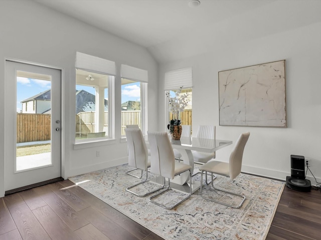 dining area with dark wood-type flooring and lofted ceiling