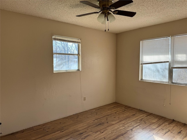 spare room featuring a textured ceiling, ceiling fan, and light hardwood / wood-style floors