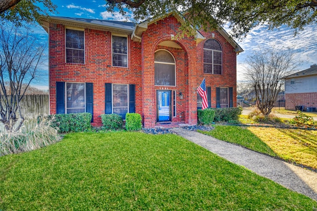 view of front of home featuring brick siding, a front lawn, and fence