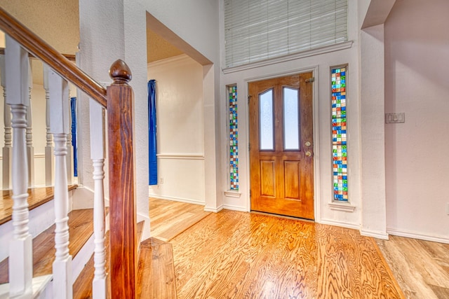 entrance foyer with stairs, baseboards, and wood finished floors