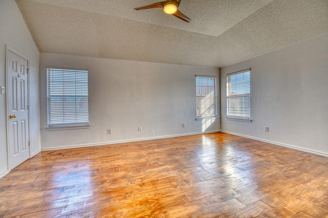 empty room featuring ceiling fan, baseboards, a textured ceiling, and wood finished floors