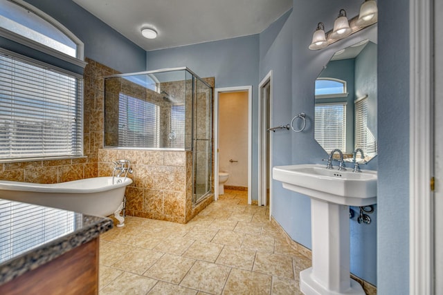 full bathroom featuring a soaking tub, toilet, and a stall shower