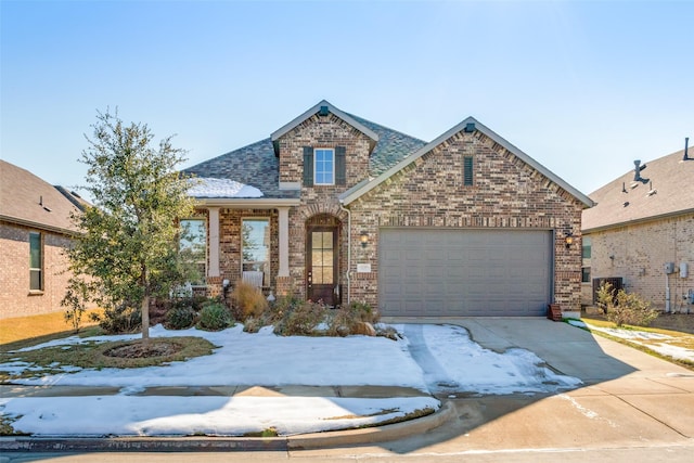 view of front of house with driveway, an attached garage, a shingled roof, and brick siding