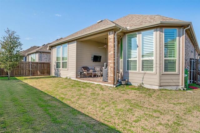 back of property featuring a yard, ceiling fan, and a patio area