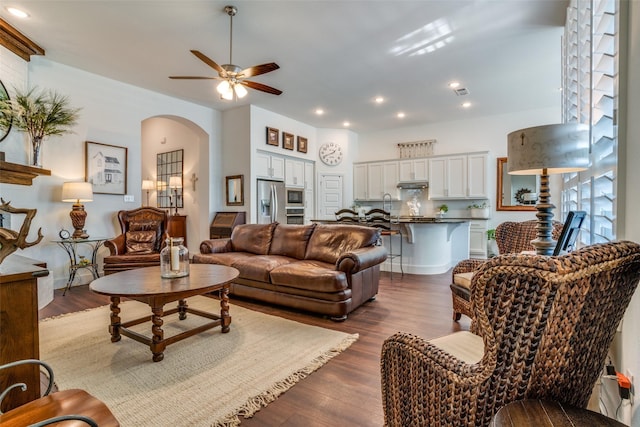 living room with dark wood-type flooring and ceiling fan