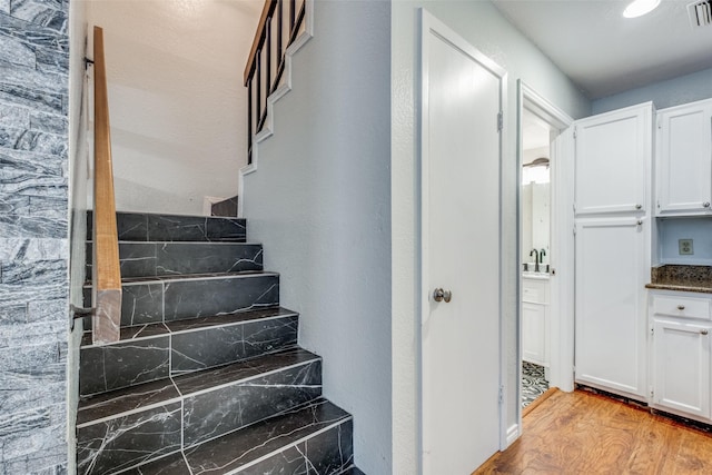 staircase with hardwood / wood-style flooring