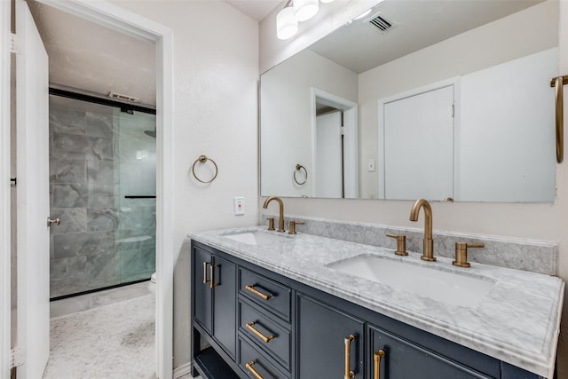 bathroom featuring a shower with door and vanity