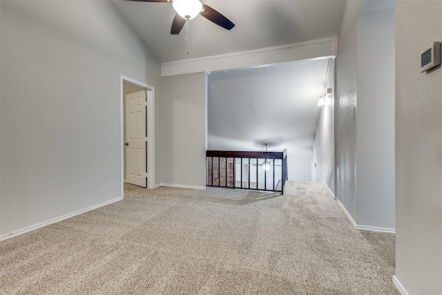 carpeted spare room with ceiling fan and lofted ceiling