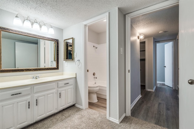 full bathroom with toilet, vanity, hardwood / wood-style flooring, a textured ceiling, and shower / bathing tub combination