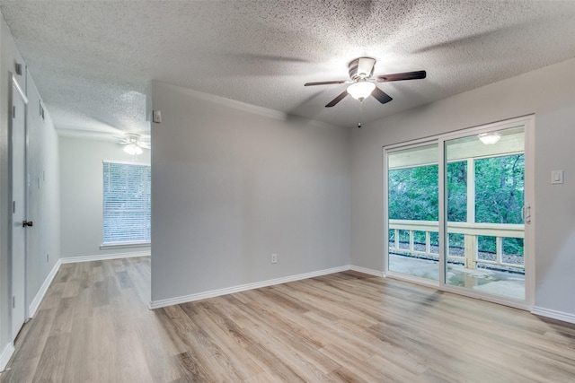 spare room featuring a textured ceiling, light wood-type flooring, and ceiling fan