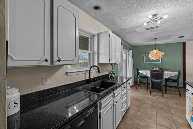 kitchen featuring dishwasher, sink, white cabinets, hanging light fixtures, and a textured ceiling