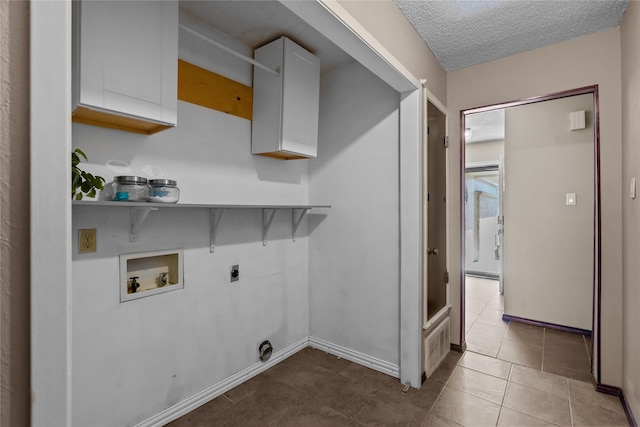 clothes washing area featuring cabinets, a textured ceiling, light tile patterned floors, hookup for a washing machine, and electric dryer hookup