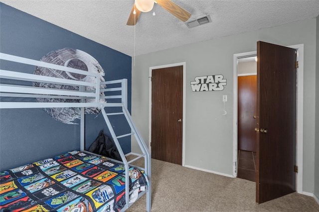 carpeted bedroom with a textured ceiling and ceiling fan