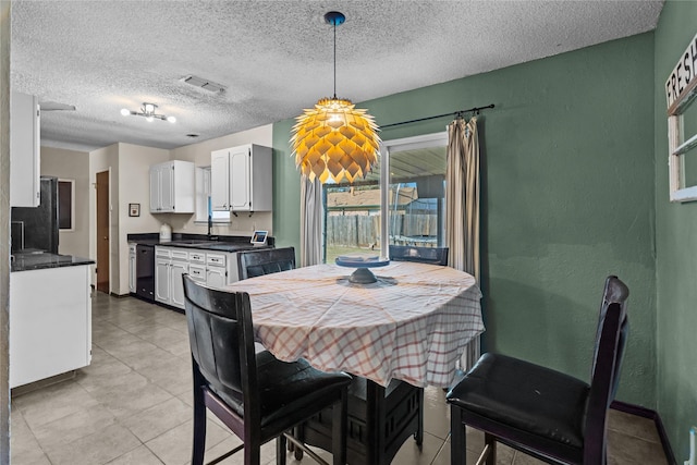 dining space featuring sink and a textured ceiling