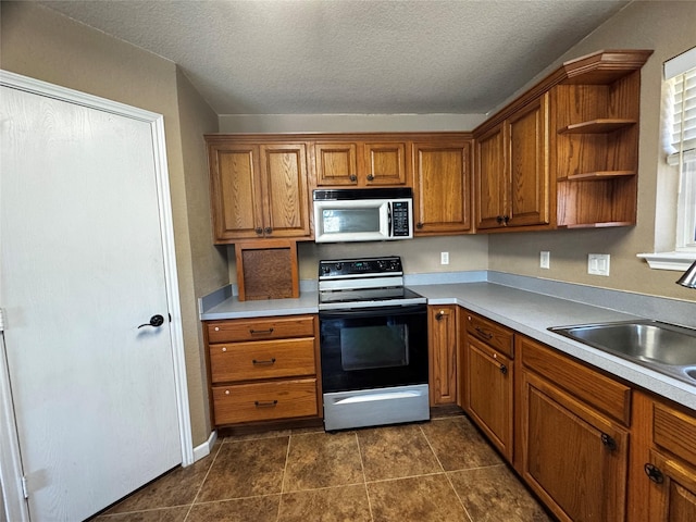 kitchen featuring sink, a wealth of natural light, electric range, and a textured ceiling