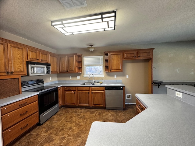 kitchen featuring sink, stainless steel appliances, and dark tile patterned floors