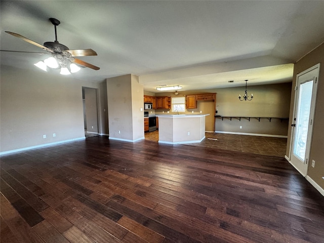 unfurnished living room with vaulted ceiling, sink, ceiling fan with notable chandelier, and dark hardwood / wood-style flooring