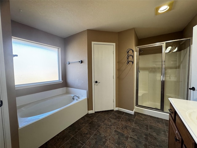 bathroom with vanity, separate shower and tub, and a textured ceiling