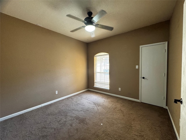 carpeted spare room featuring ceiling fan