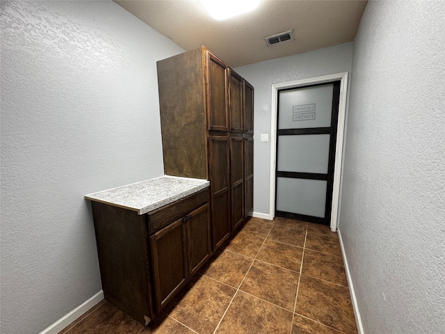 hallway featuring dark tile patterned flooring