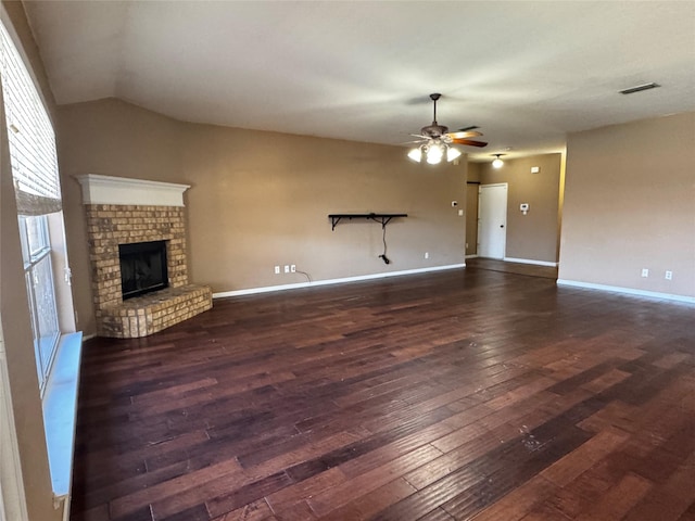 unfurnished living room with lofted ceiling, a brick fireplace, dark hardwood / wood-style floors, and ceiling fan