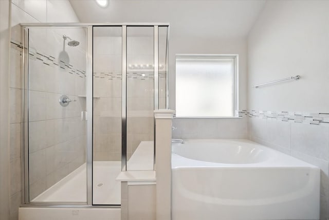 bathroom featuring lofted ceiling and separate shower and tub