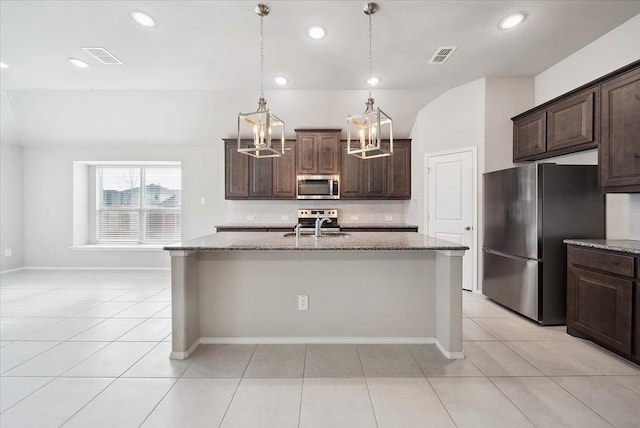 kitchen with stainless steel appliances, a center island with sink, and dark brown cabinets