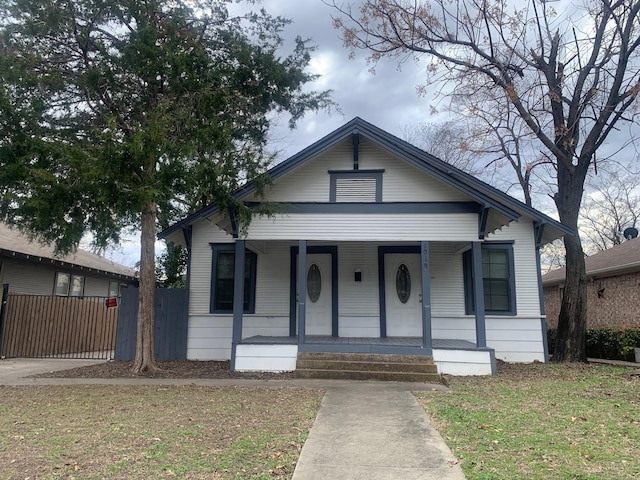 bungalow-style home with covered porch and a front lawn