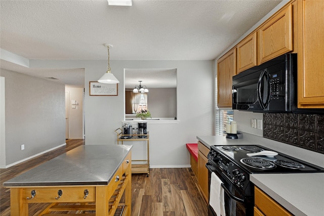 kitchen featuring dark wood-type flooring, a textured ceiling, hanging light fixtures, black appliances, and an inviting chandelier