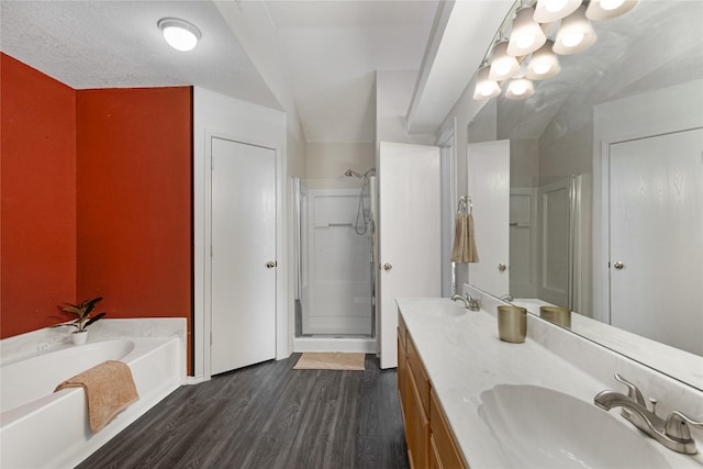 bathroom with vanity, a textured ceiling, hardwood / wood-style floors, and separate shower and tub