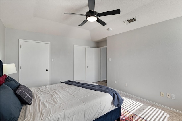 carpeted bedroom featuring lofted ceiling and ceiling fan