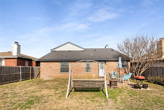 rear view of property featuring a yard and a patio