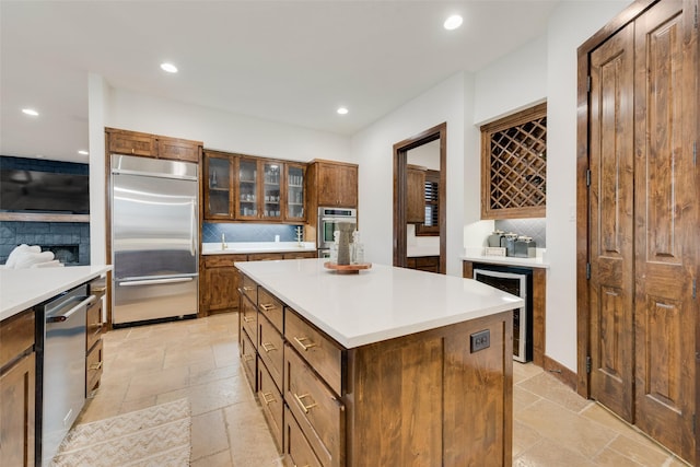 kitchen with stainless steel appliances, a center island, beverage cooler, and decorative backsplash