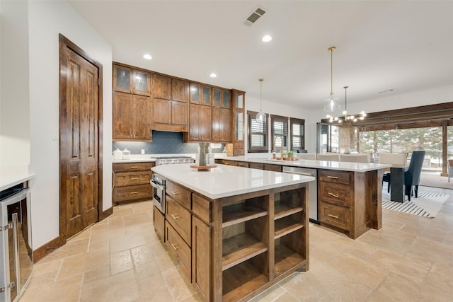 kitchen featuring appliances with stainless steel finishes, a kitchen island, decorative light fixtures, wine cooler, and decorative backsplash