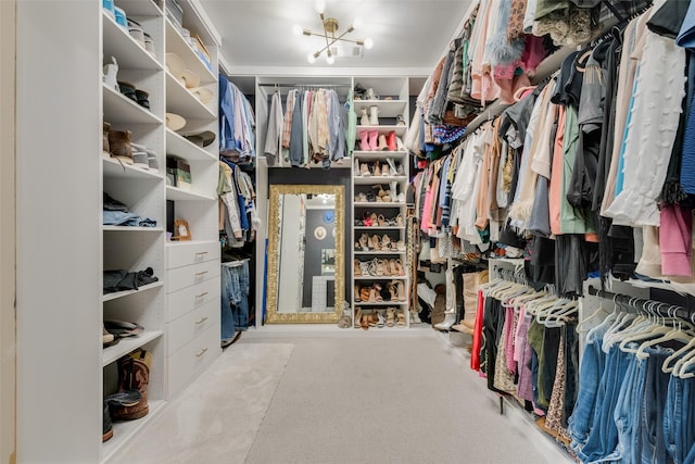 walk in closet with a notable chandelier