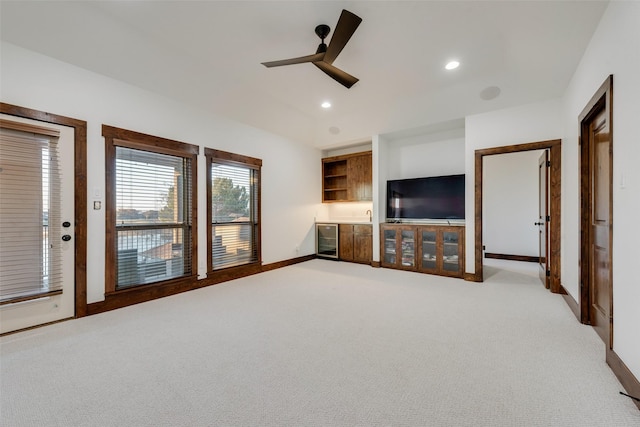 unfurnished living room featuring light carpet, wine cooler, and ceiling fan