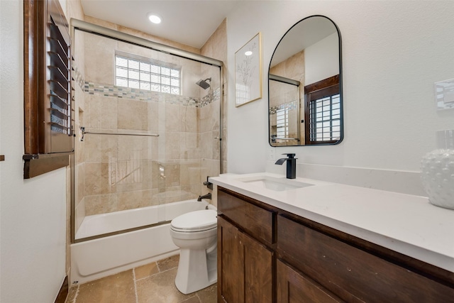 full bathroom featuring toilet, shower / bath combination with glass door, and vanity