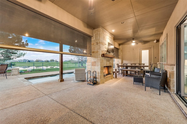 view of patio / terrace with an outdoor stone fireplace and central AC