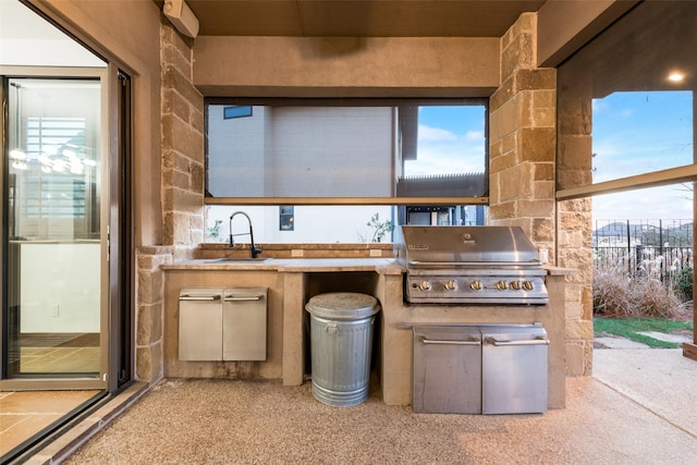 view of patio with exterior kitchen, sink, and a grill