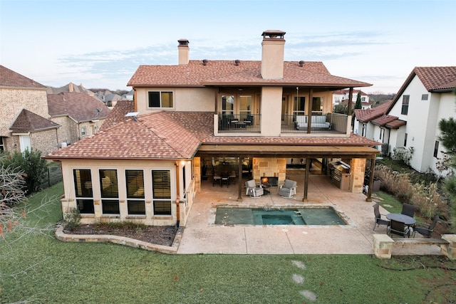 rear view of house featuring a swimming pool with hot tub, an outdoor living space, a lawn, and a patio