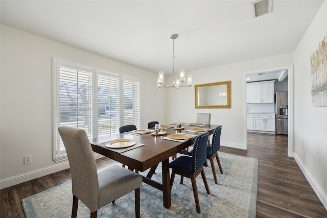 dining room with dark wood-type flooring and a notable chandelier