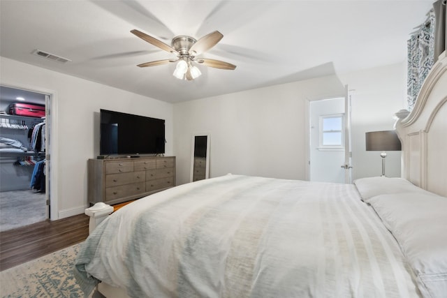 bedroom with hardwood / wood-style floors, a closet, ceiling fan, and a spacious closet