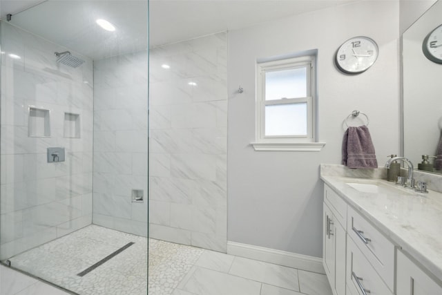 bathroom featuring tiled shower and vanity